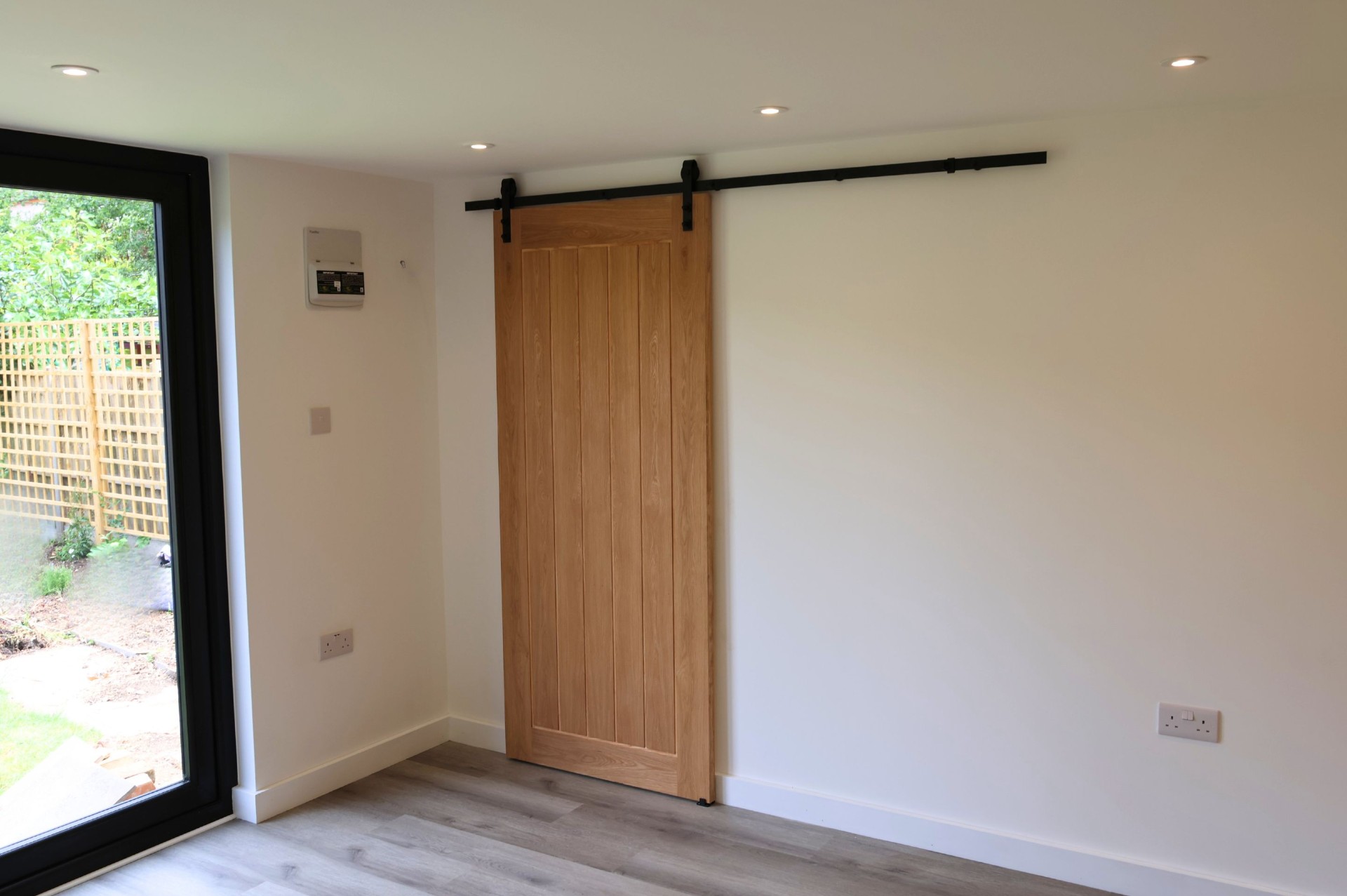 Interior of the Coulsdon garden room with internal oak barn-style sliding door