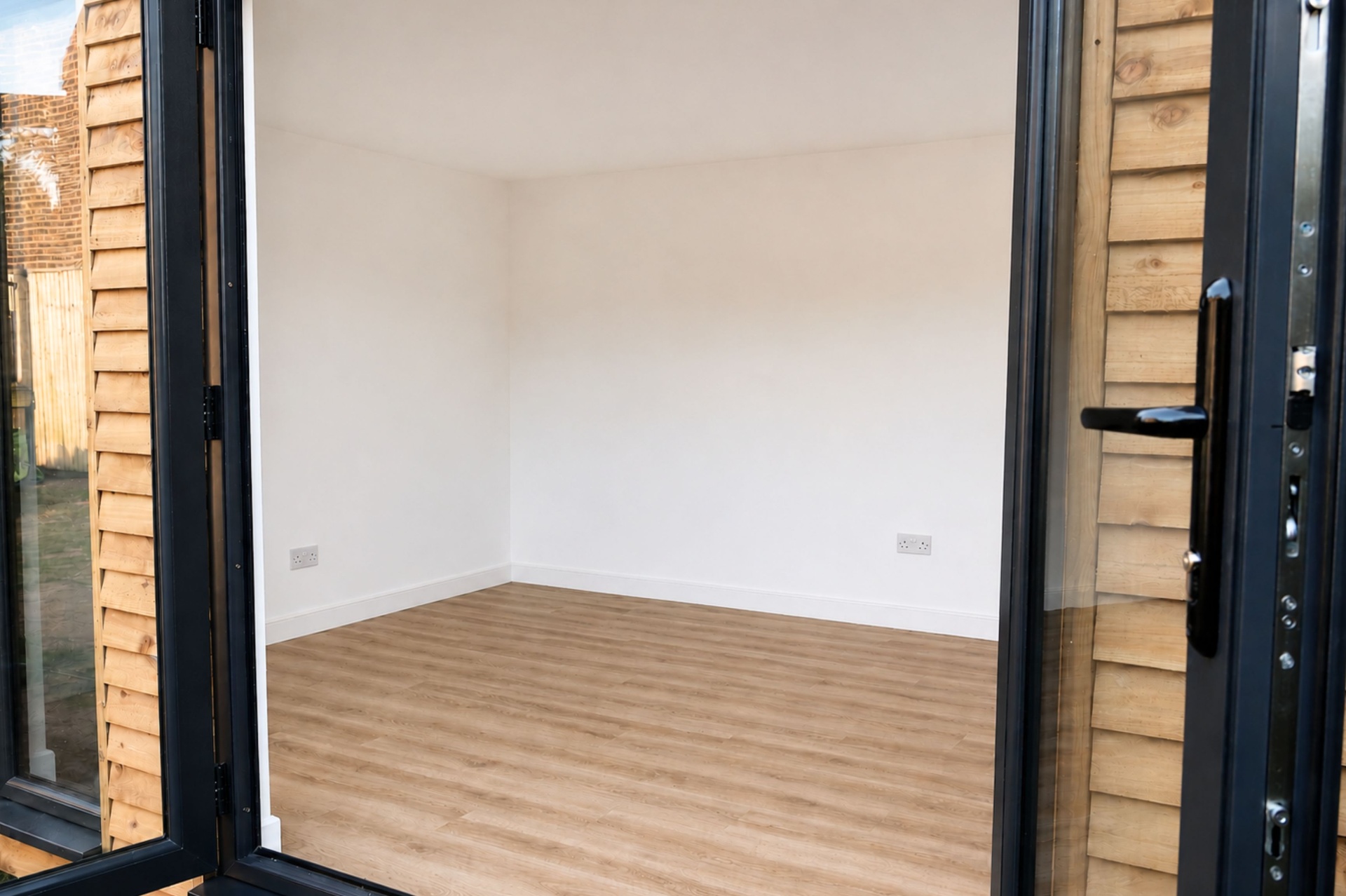 Inside the country cottage garden room - bright plastered walls and warm oak-plank flooring