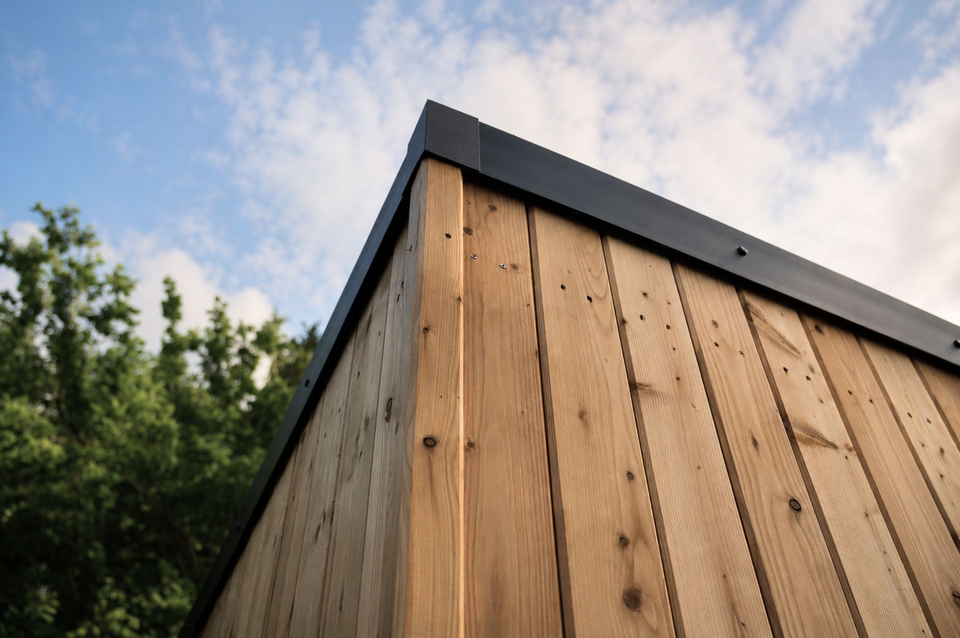 Detail of Siberian larch cladding with black aluminium roof trim