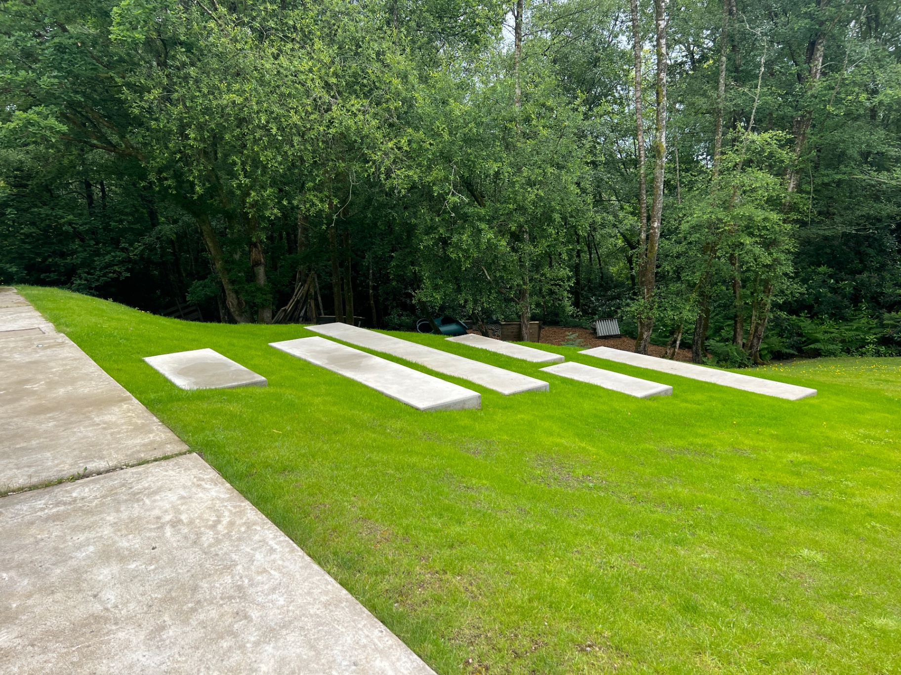 Sculptural arrangement of cast concrete blocks set into the sloping lawn