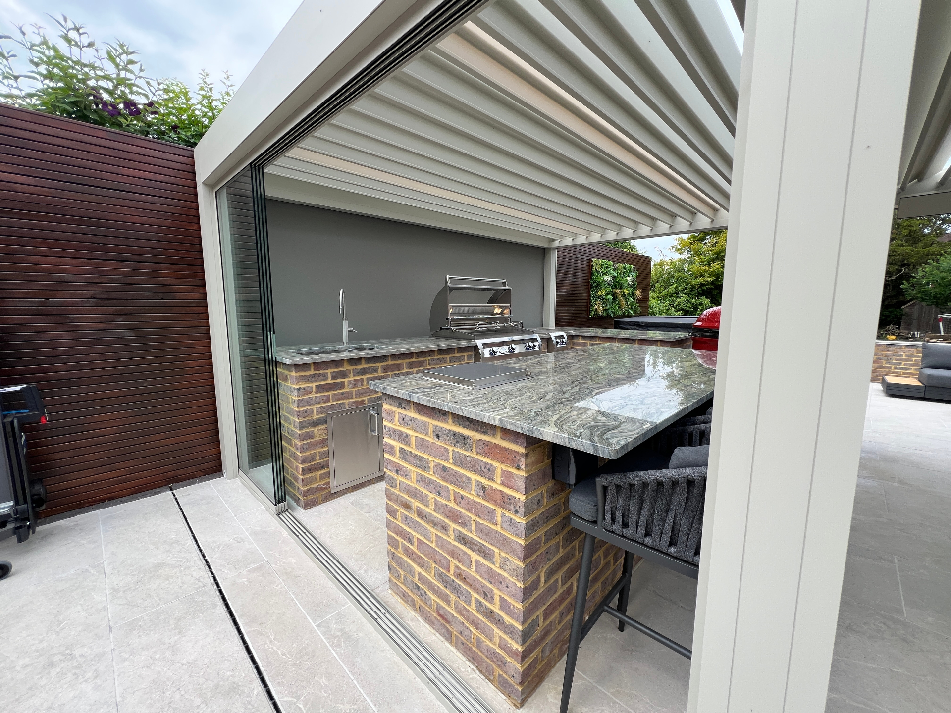Glazed pergola corner with brick bar and grill
