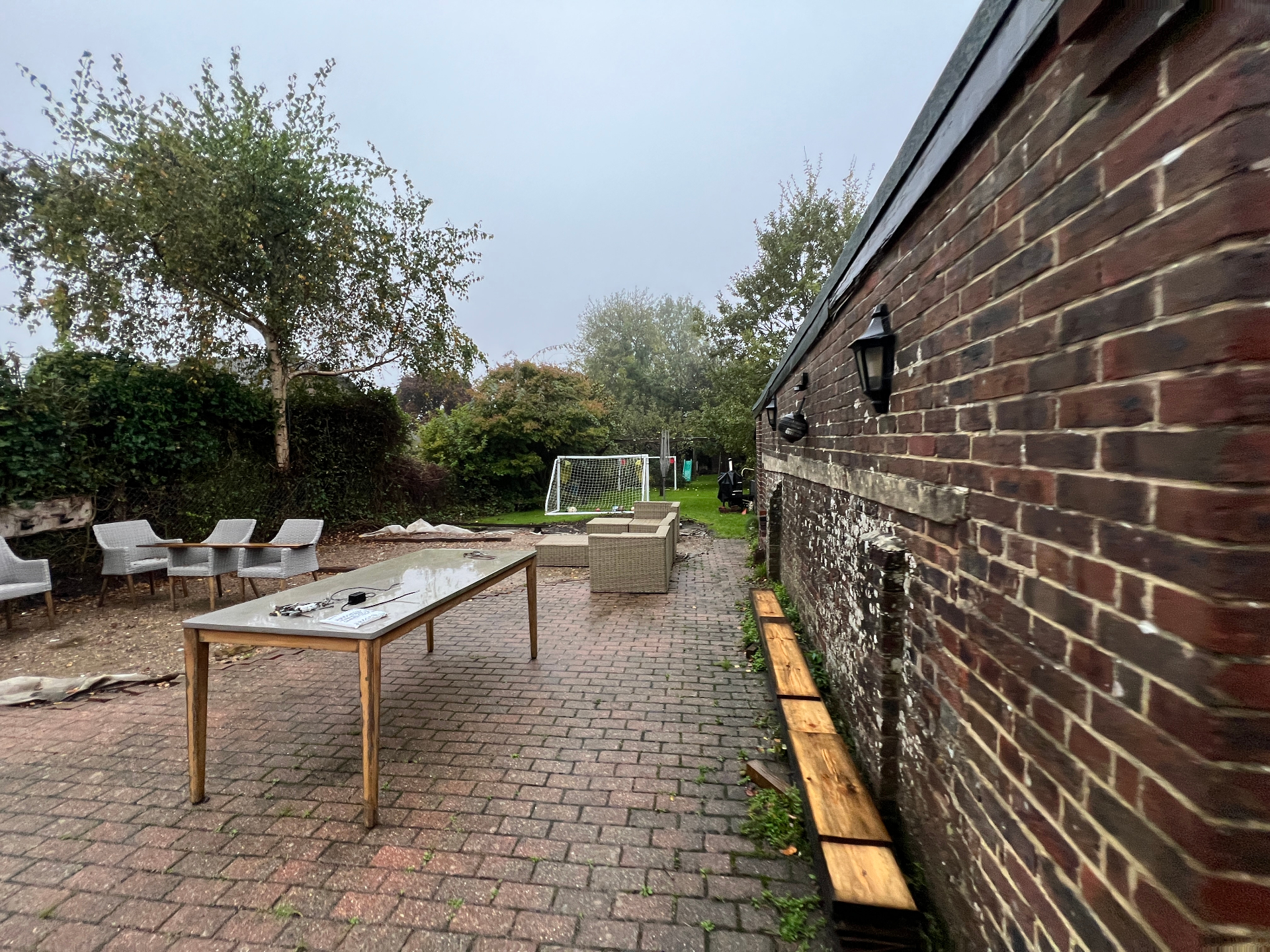 Original garden — dated block paving patio with rattan furniture and bare brick boundary