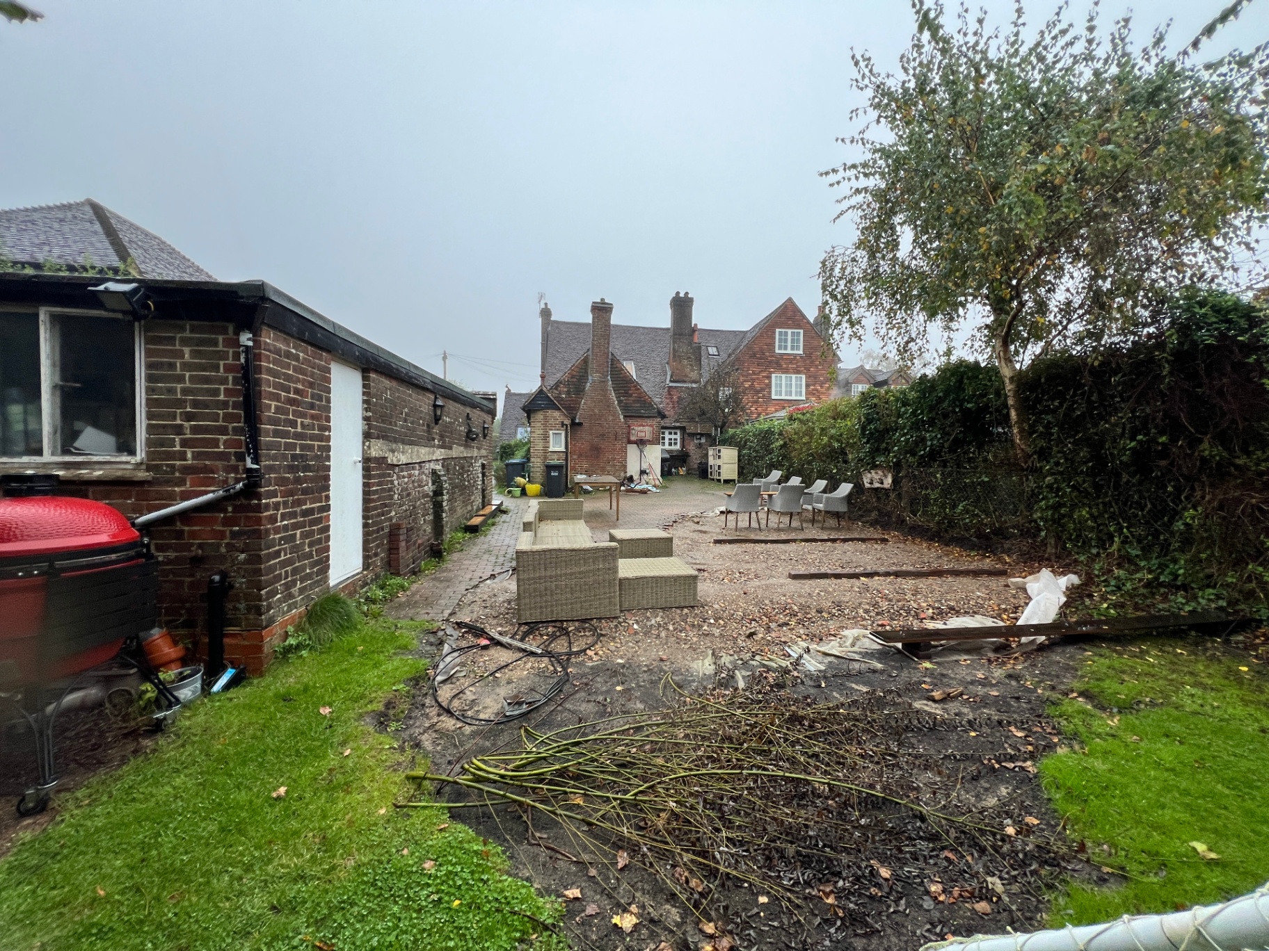 Original garden — gravel area, scattered furniture and overgrown lawn before transformation
