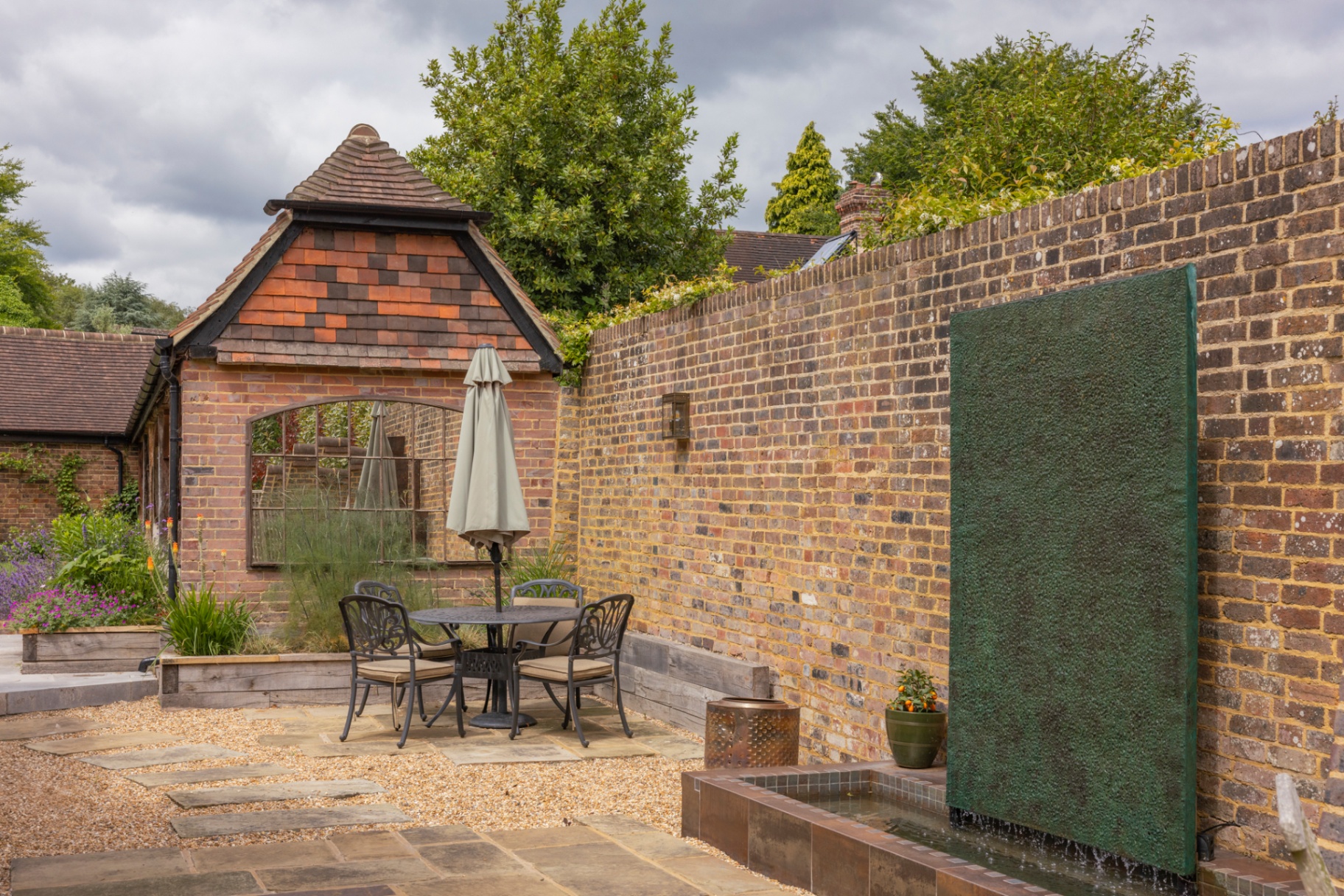 Walled courtyard with copper water feature and bistro seating