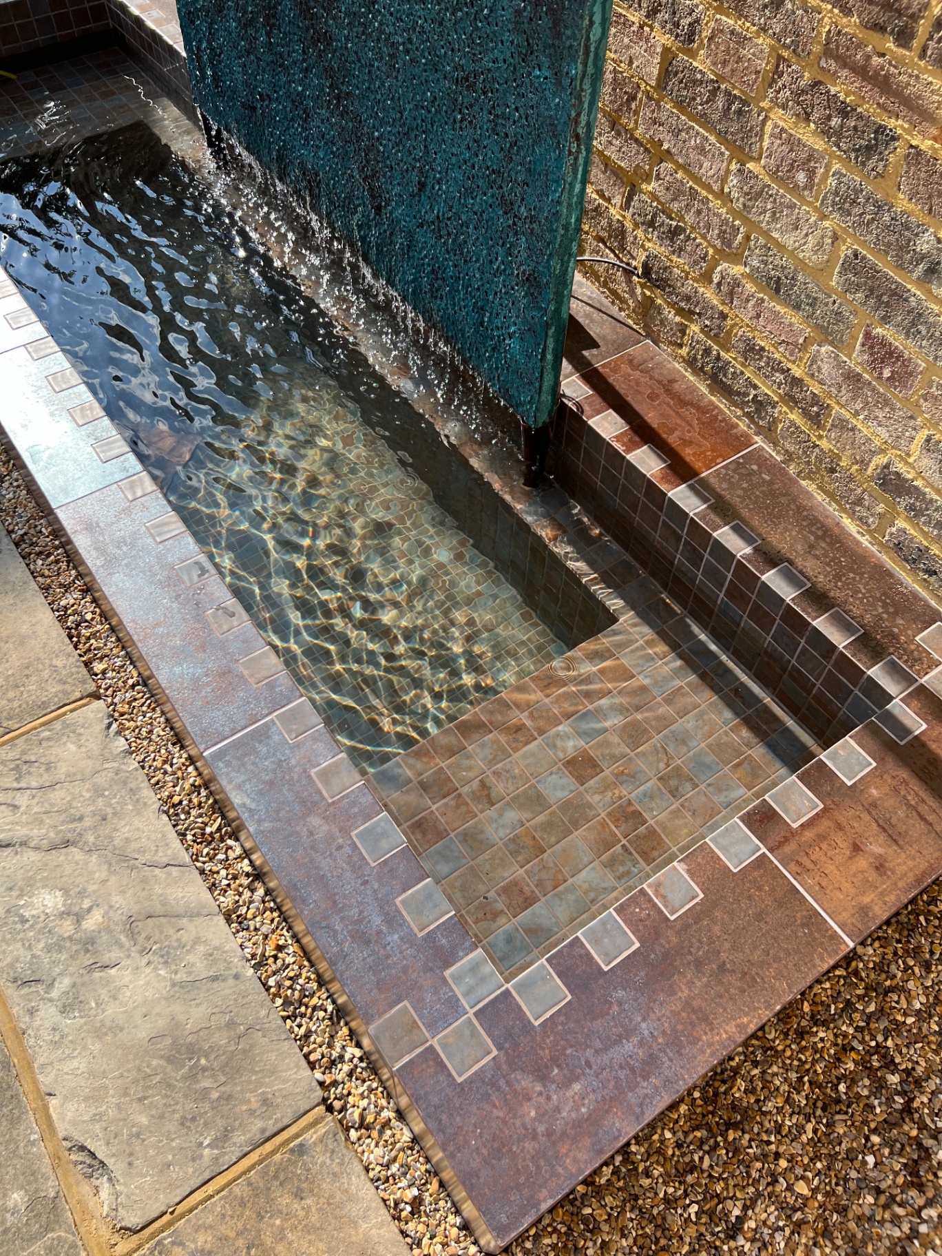 Detail of copper-edged water feature with verdigris cascade