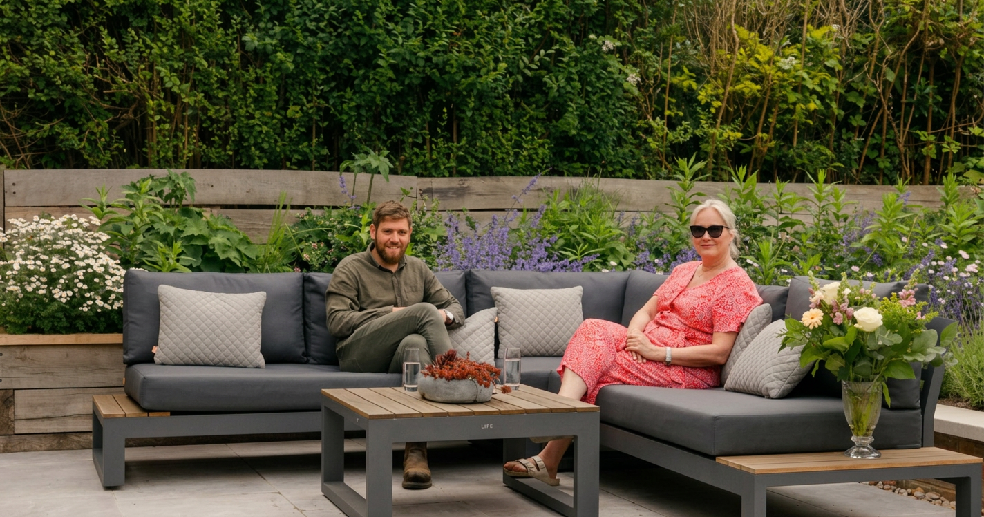 Alistair sitting in the finished garden alongside the client who commissioned it