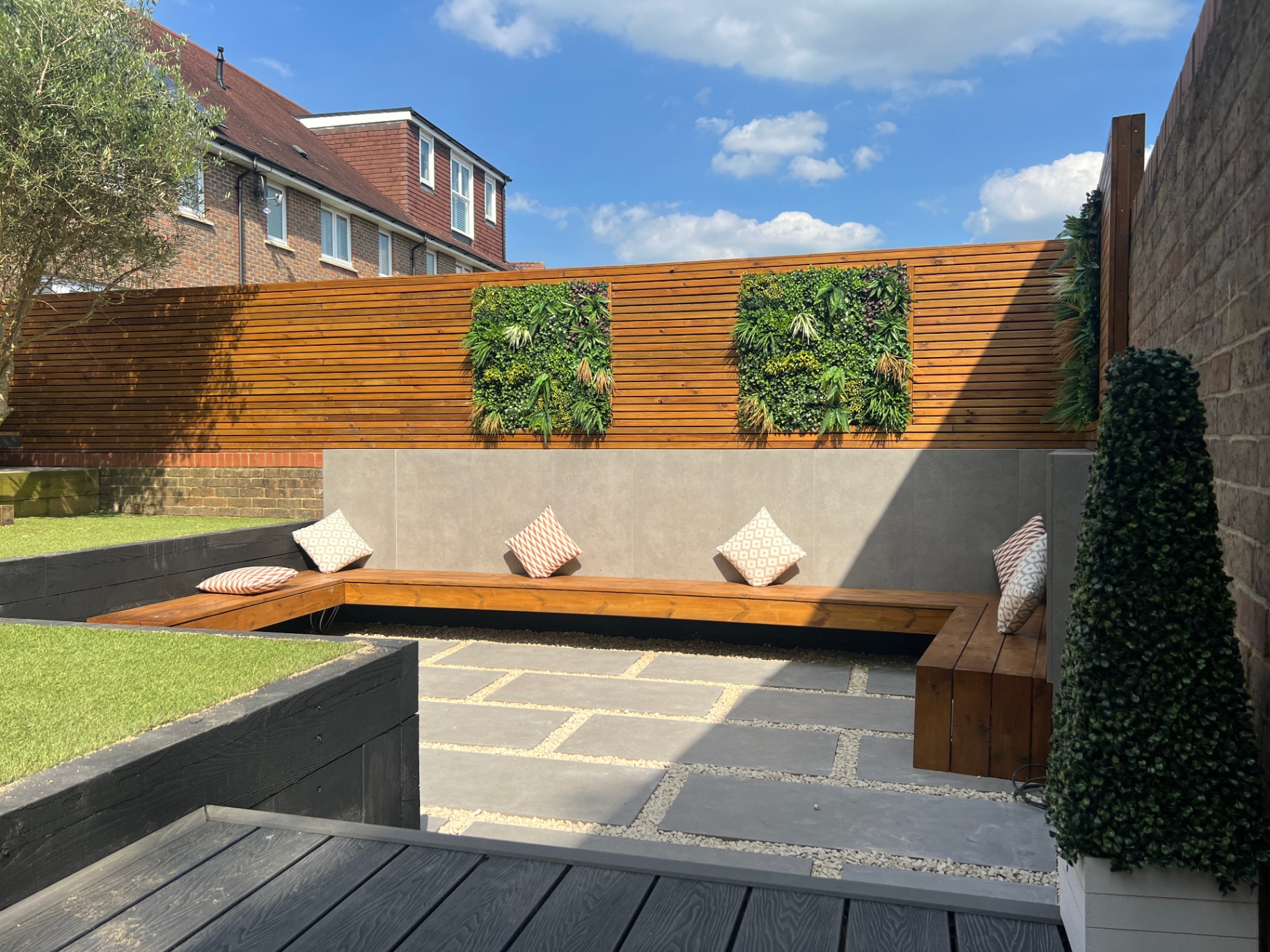 Sunken seating area with cedar slat fence, living wall panels and porcelain paving