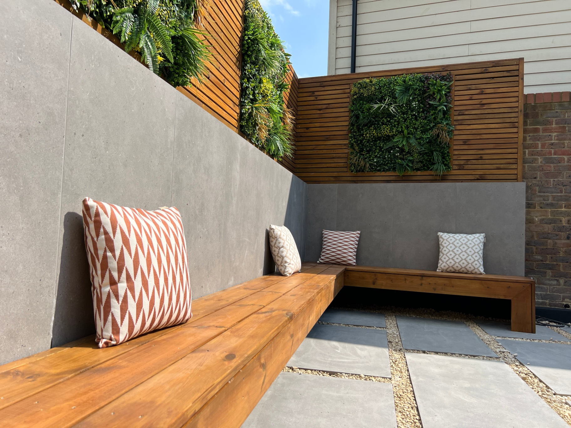 Sunken corner bench with cedar cladding, living wall panel and patterned outdoor cushions