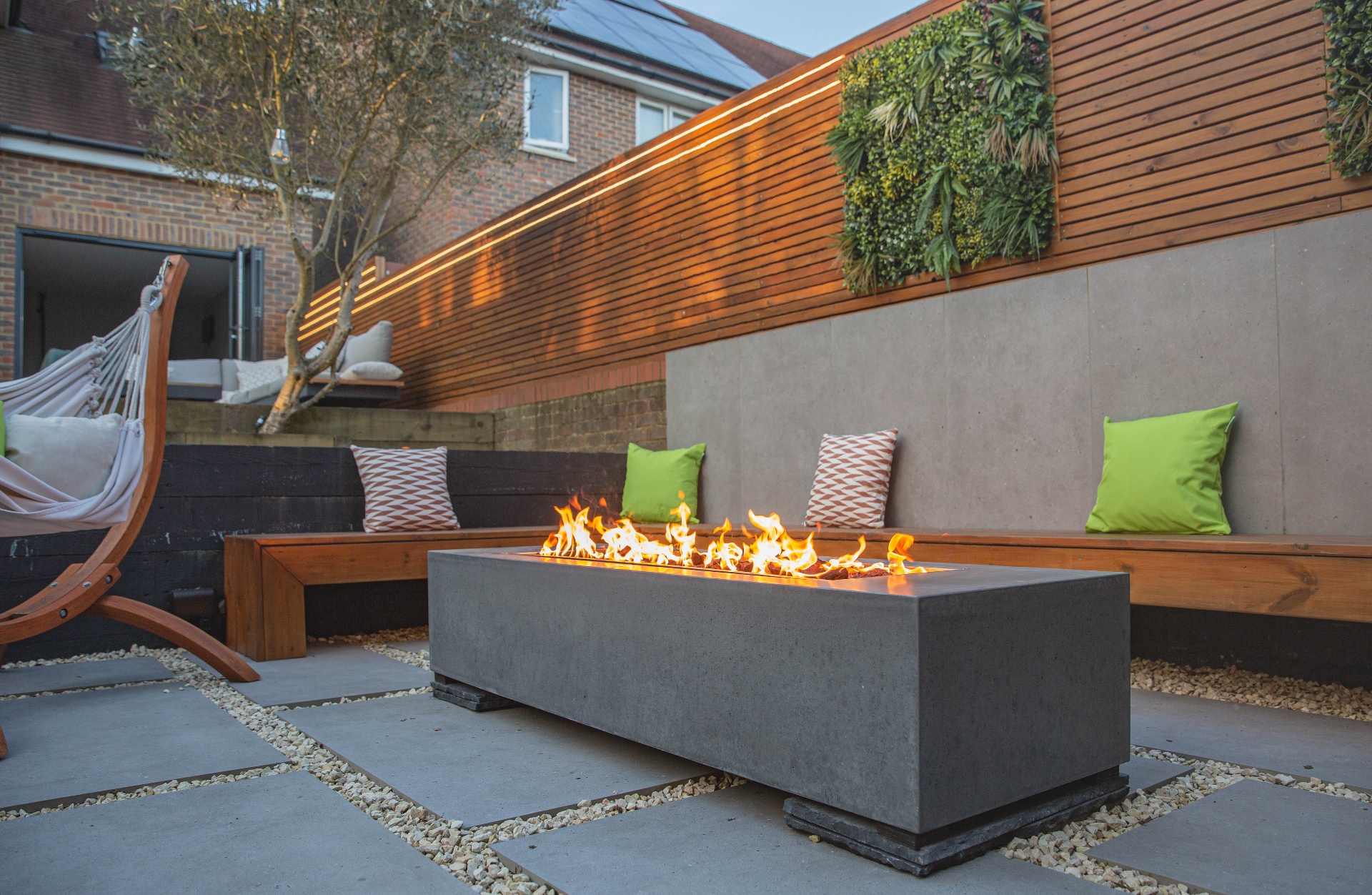 Evening atmosphere with hammock, glowing fire pit and warm cedar wall lighting