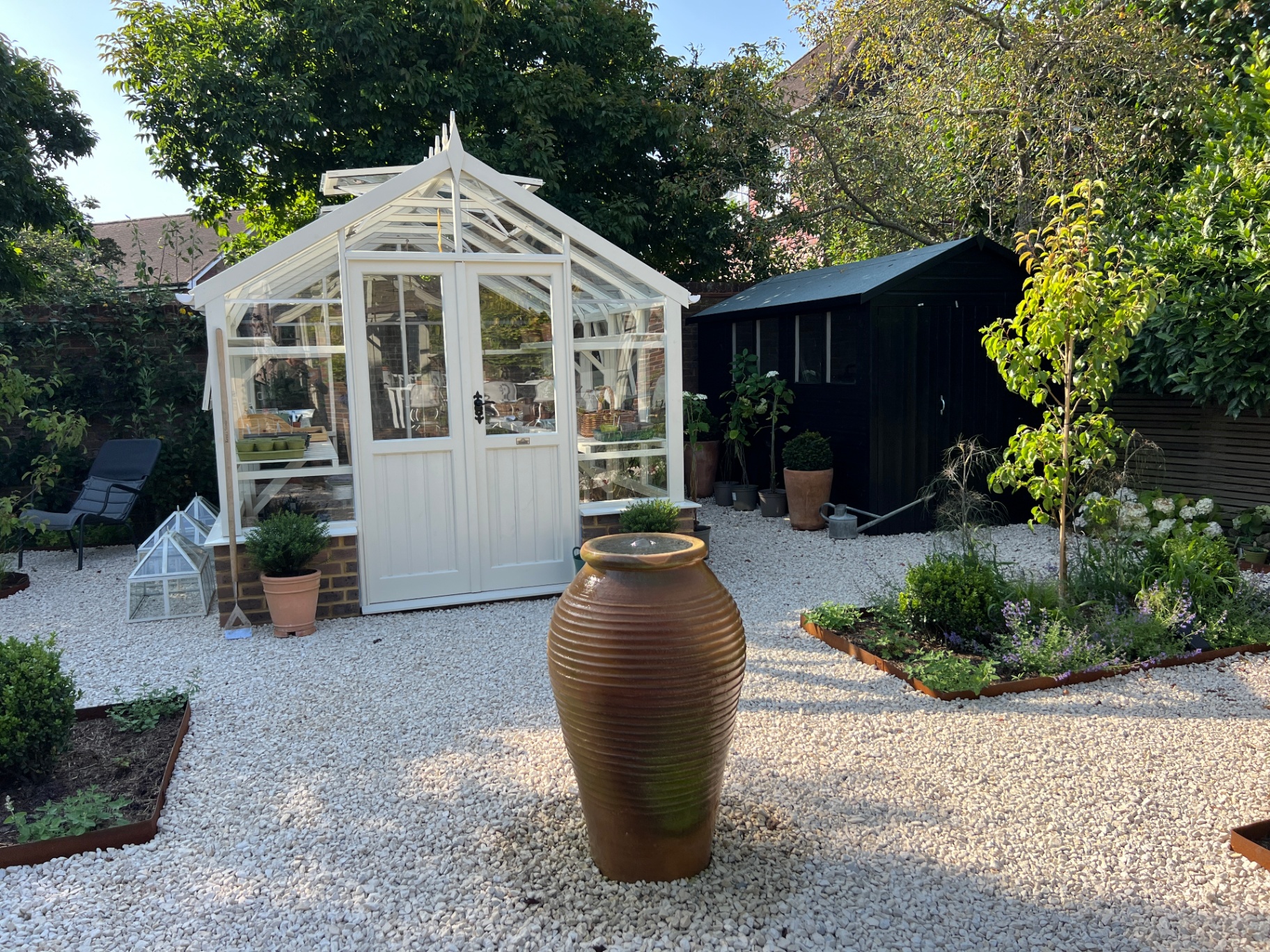 Walled flower garden — glasshouse, urn and cold frame in golden afternoon light
